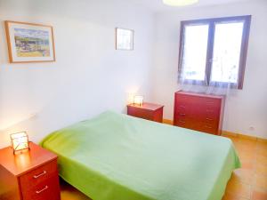カネ・アン・ルシヨンにあるApartment Les Voiliers by Interhomeのベッドルーム1室(緑のベッド1台、ナイトスタンド2台付)