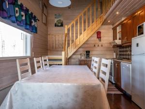 Una cocina con una mesa con sillas y un refrigerador. en Holiday Home Naurisniemi by Interhome, en Hankamäki