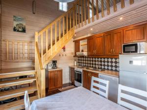 una cocina con armarios de madera y una escalera en Holiday Home Naurisniemi by Interhome, en Hankamäki