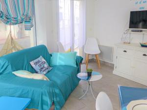 un soggiorno con divano blu e TV di Apartment Ô petit bonheur by Interhome a Houlgate