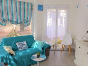 un soggiorno con divano blu e finestra di Apartment Ô petit bonheur by Interhome a Houlgate