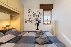 a bedroom with a bed with towels and a tree on the wall at ASIAGO - Chalet panoramico con Wifi e Free Parking in Gallio