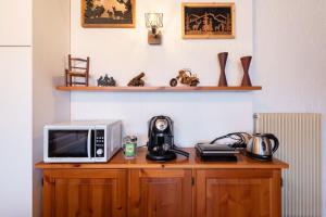 a microwave sitting on top of a wooden cabinet at ASIAGO - Chalet panoramico con Wifi e Free Parking in Gallio