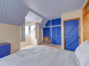 ブロードステアーズにあるHoliday Home Shutler by Interhomeの青いドアと椅子付きのベッドルーム1室