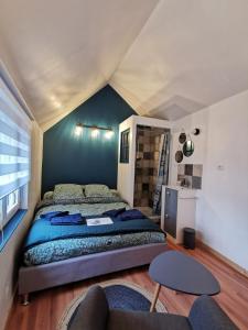 ein Schlafzimmer mit einem Bett und einer blauen Wand in der Unterkunft Le 5 in Plouézec