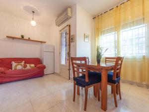 a living room with a table and a red couch at Apartment Marie by Interhome in Torredembarra