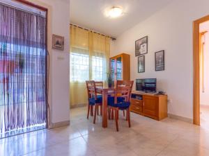 a dining room with a table and chairs and a television at Apartment Marie by Interhome in Torredembarra +22 photos