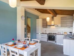 a kitchen with a white table and chairs in a room at Holiday Home Il Fienile del Casolare by Interhome in Penna