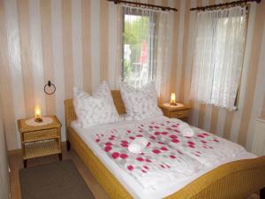 a bedroom with a bed with red roses on it at Holiday Home Siglinde by Interhome in Goldberg