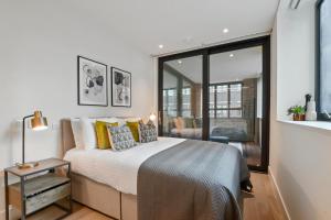 a bedroom with a large bed with yellow pillows at Whitfield Street Residences by Q Apartments in London