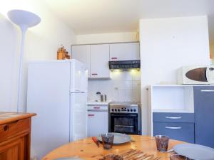 ビダールにあるApartment Zirlinga-4 by Interhomeのキッチン(白い家電製品、木製テーブル付)