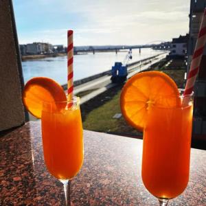 two glasses of orange juice sitting on a table at Pension Oderblick in Frankfurt Oder