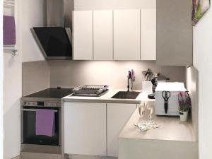 una cucina con armadi bianchi e piano cottura di Apartment Aldesago Monte Brè - Utoring-1 by Interhome a Aldesago
