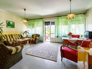 un soggiorno con divano, sedie e TV di Holiday Home Mango by Interhome a Zamárdi