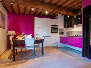 Holiday Home Casa Francesca by Interhome في Rosia: مطبخ مع طاولة خشبية وجدران ارجوانية