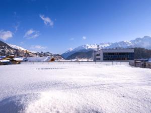 a snow covered parking lot with mountains in the background at Apartment Chesa Piz Mezdi - St- Moritz by Interhome in St. Moritz