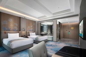 a hotel room with two beds and a television at Wyndham Changzhou Liyang in Liyang +60 photos