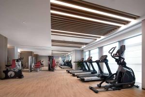 a gym with treadmills and ellipticals in a room at Wyndham Changzhou Liyang in Liyang