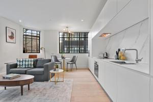 a living room with a couch and a kitchen at Whitfield Street Residences by Q Apartments in London