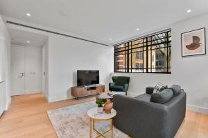 a living room with a couch and a tv at Whitfield Street Residences by Q Apartments in London
