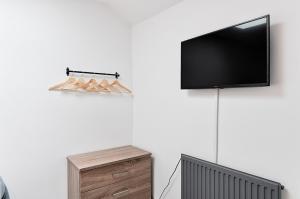 TV de pantalla plana colgada en una pared junto a un tocador en Spacious 3 Bed - Smart TVs - Great for Work Stays, en Swansea