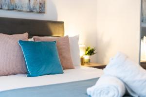 Un dormitorio con una cama con almohadas azules y rosas. en Spacious 3 Bed - Smart TVs - Great for Work Stays, en Swansea