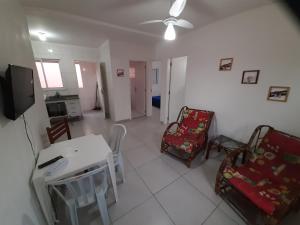 a living room with a table and chairs and a television at Cristal Boraceia IV apto 28 - check-out 15h in Bertioga