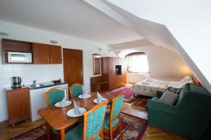 a kitchen and living room with a table and chairs at HELIOS Hotel Apartments in Budapest