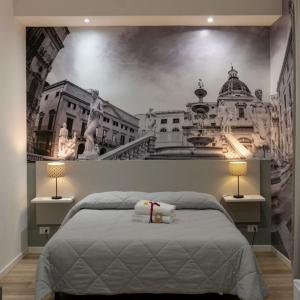 una camera da letto con un murale raffigurante una città di Due Passi Suite a Palermo