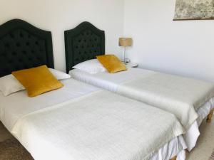 two beds sitting next to each other in a room at résidence les oliviers in Soliman