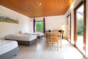 um quarto com duas camas e uma mesa e cadeiras em RAJ Living - 6 Room Villa with Garden - 15 Min Messe DUS & Airport DUS em Meerbusch