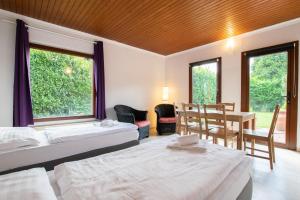 a bedroom with two beds and a table and chairs at RAJ Living - 6 Room Villa with Garden - 15 Min Messe DUS & Airport DUS in Meerbusch
