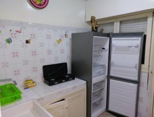 uma cozinha com um frigorífico aberto e um lavatório em Appartement Hamria RiF em Meknès