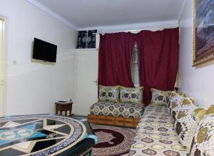 a living room with a couch and a tv at Appartement Hamria RiF in Meknès