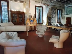 una sala de estar con sofás blancos y una mesa. en Palazzo cinquecentesco con giardino interno, en Verona