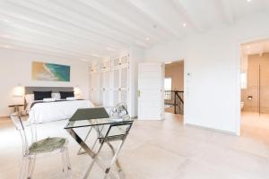 ein weißes Schlafzimmer mit einem Bett und einem Glastisch in der Unterkunft Can Maties in Santa Margalida