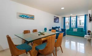 a dining room and living room with a table and chairs at White Coral ApartaSuites in San Andrés