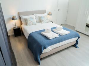 1 dormitorio con 1 cama grande y toallas. en CM VINTAGE Apartments - Breiner, en Oporto