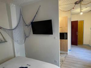 um quarto com uma televisão de ecrã plano na parede em Ocean ROOM em Romans-sur-Isère