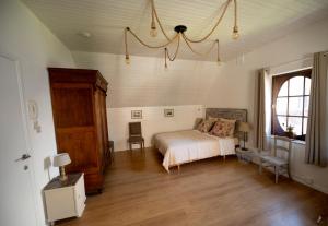 een slaapkamer met een bed en een groot raam bij Les 3 chapeaux Dinant in Dinant