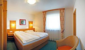 - une chambre avec un lit, une chaise et une fenêtre dans l'établissement Haus Birgit, à Bad Füssing