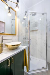 a bathroom with a glass shower with a sink at Glamorous Apartment Old Town Cracow in Kraków