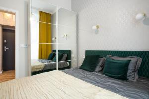 sypialnia z łóżkiem i dużym lustrem w obiekcie Glamorous Apartment Old Town Cracow w Krakowie