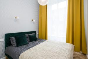 sypialnia z łóżkiem z zielonymi i żółtymi zasłonami w obiekcie Glamorous Apartment Old Town Cracow w Krakowie