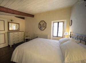 um quarto com uma grande cama branca e uma janela em La Chicca piccola casina in affitto nel Borgo Antico di Gaggio Montano BO em Gaggio Montano
