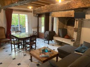 a living room with a table and a fireplace at Domaine de Villateux in Terjat