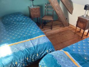 una camera con letto, sedia e pavimento in legno di Domaine de Villateux a Terjat