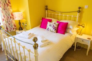 Un dormitorio con una cama blanca con almohadas rosas. en Clevedon House - Newquay - Beaches - Parking, en Newquay