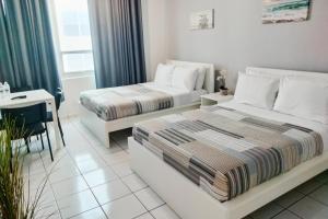 a bedroom with two beds and a desk and a table at Miami Beach Apartments by MiaRentals in Miami Beach