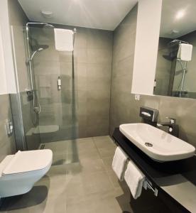 a bathroom with a toilet and a sink and a shower at DORMERO Hotel Aschaffenburg in Aschaffenburg